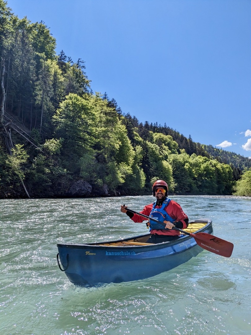 Kanufahrer mit Helm und Schwimmweste auf einem Fluss